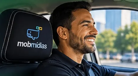 Motorista sorrindo ao volante, com o encosto de cabeça da MobMídias ao lado